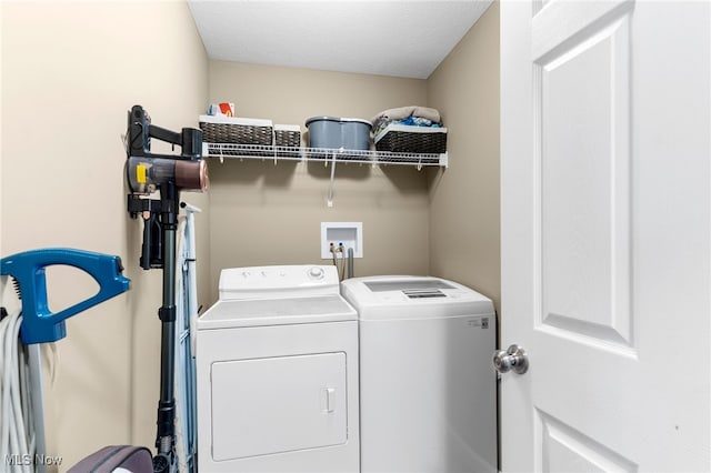 clothes washing area featuring washing machine and clothes dryer and a textured ceiling