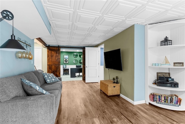 living room featuring a barn door and hardwood / wood-style flooring