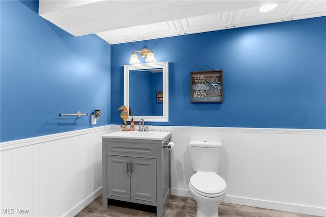 bathroom featuring wood-type flooring, vanity, and toilet