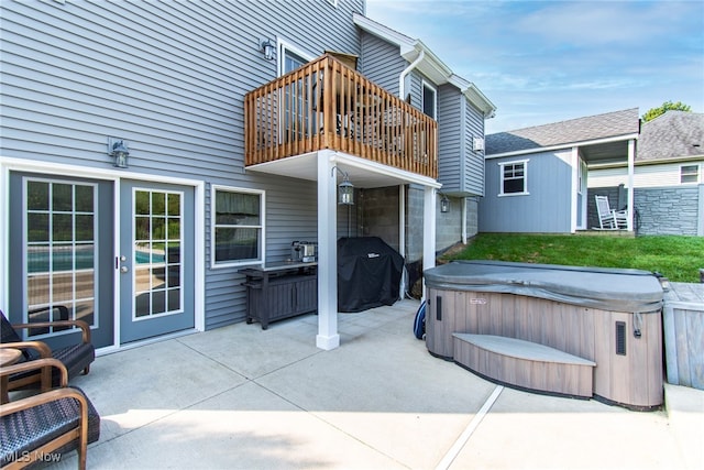 view of patio / terrace with a balcony and a hot tub