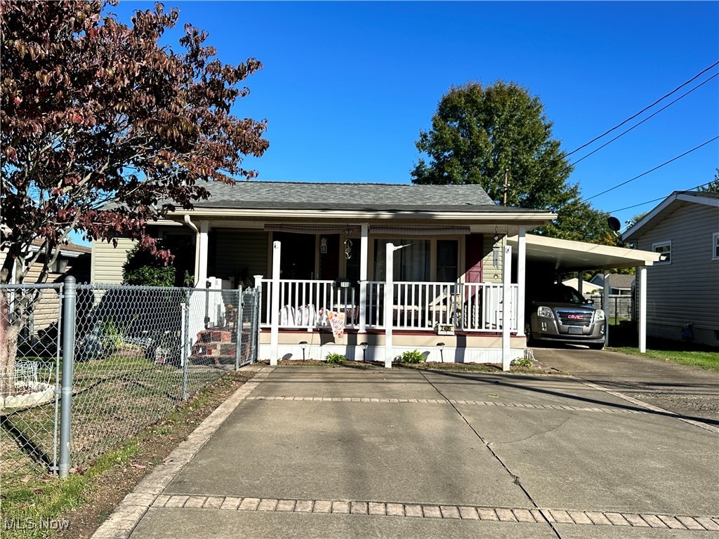 view of front of home with covered porch and a carport