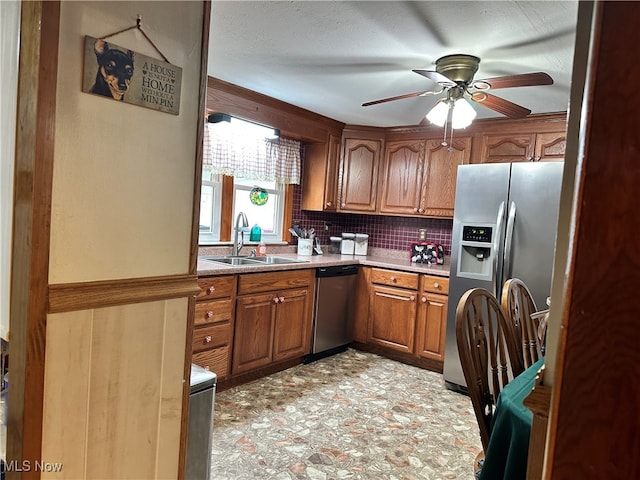 kitchen with sink, appliances with stainless steel finishes, backsplash, and ceiling fan