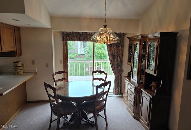 carpeted dining area featuring an inviting chandelier