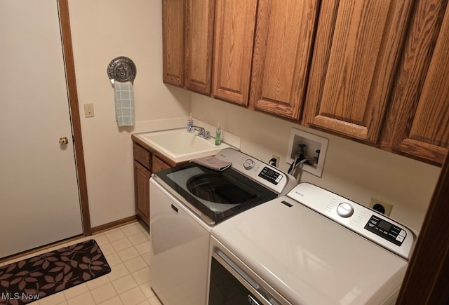 laundry room featuring cabinets, light tile patterned floors, washing machine and dryer, and sink