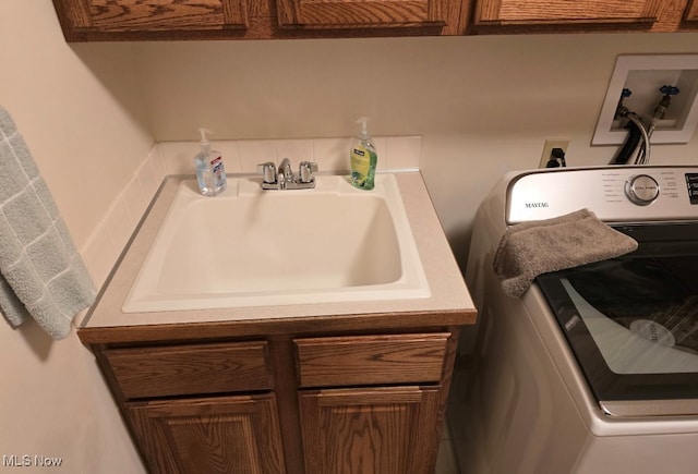 washroom featuring cabinets, washer / clothes dryer, and sink