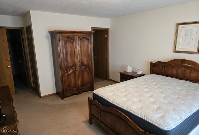 bedroom with a textured ceiling and light carpet