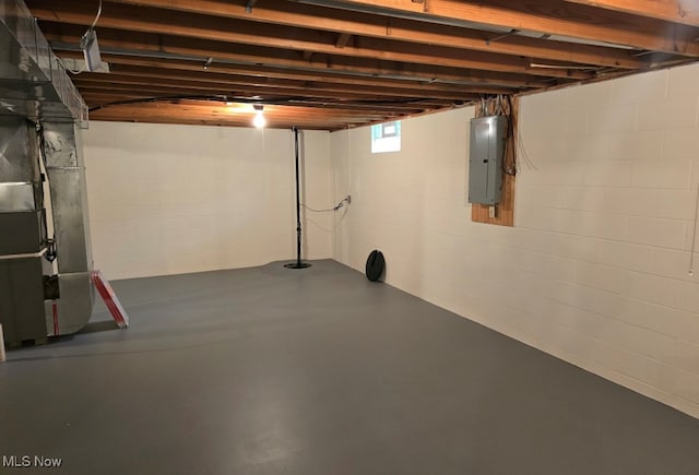 basement featuring electric panel and heating unit