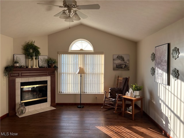 sitting room featuring ceiling fan, vaulted ceiling, dark hardwood / wood-style floors, and a fireplace