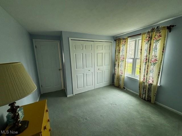unfurnished bedroom featuring carpet, a closet, and baseboards