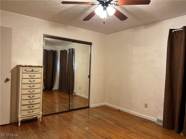 unfurnished bedroom featuring a closet, hardwood / wood-style flooring, and ceiling fan