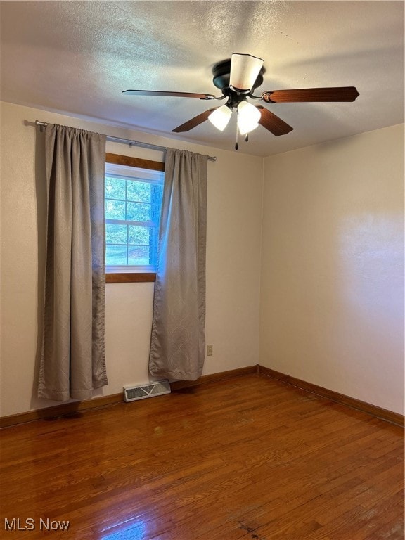 spare room featuring hardwood / wood-style flooring, a textured ceiling, and ceiling fan