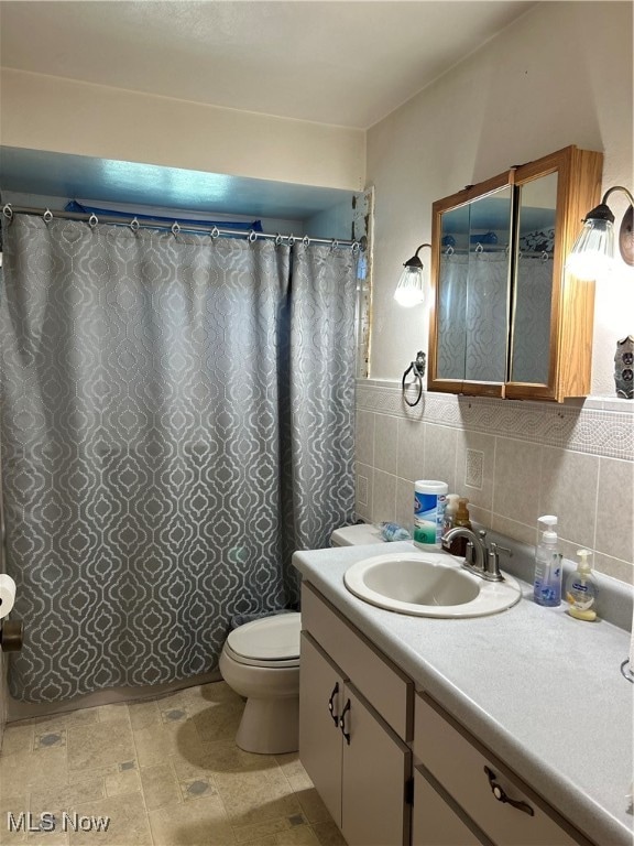 bathroom featuring tile walls, vanity, and toilet