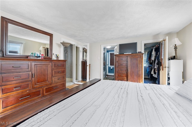 bedroom with connected bathroom, a closet, and a textured ceiling