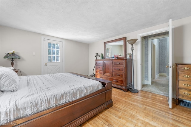 bedroom featuring a textured ceiling and light hardwood / wood-style floors