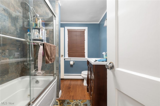 full bathroom with hardwood / wood-style floors, vanity, combined bath / shower with glass door, crown molding, and a baseboard radiator