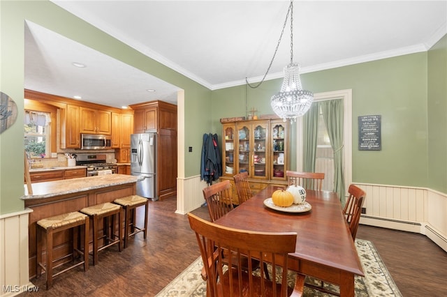 dining space with dark hardwood / wood-style floors, ornamental molding, sink, and a chandelier