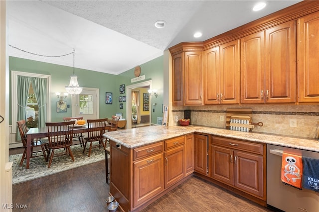 kitchen featuring kitchen peninsula, dark hardwood / wood-style flooring, decorative light fixtures, dishwasher, and a chandelier