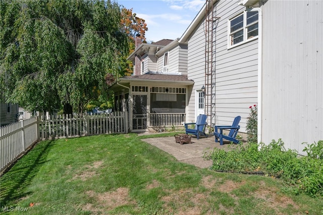 view of yard with a patio area, a sunroom, and an outdoor fire pit