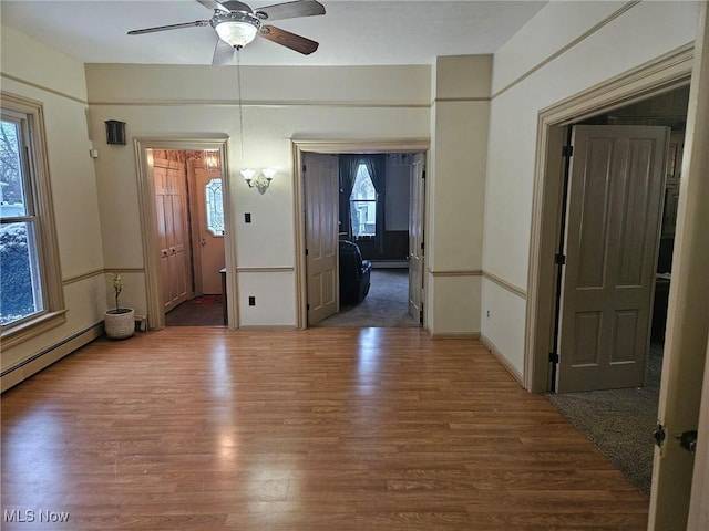 interior space featuring dark wood-type flooring, ceiling fan, and a healthy amount of sunlight