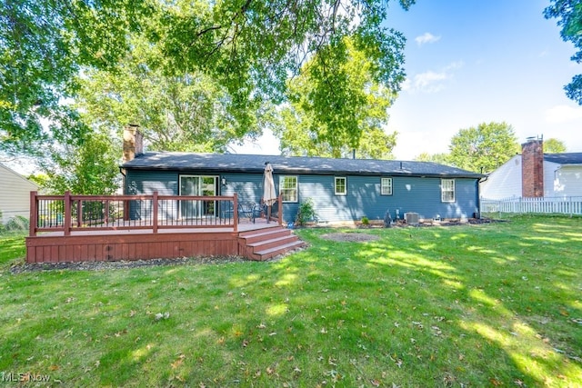 rear view of property with a lawn and a deck