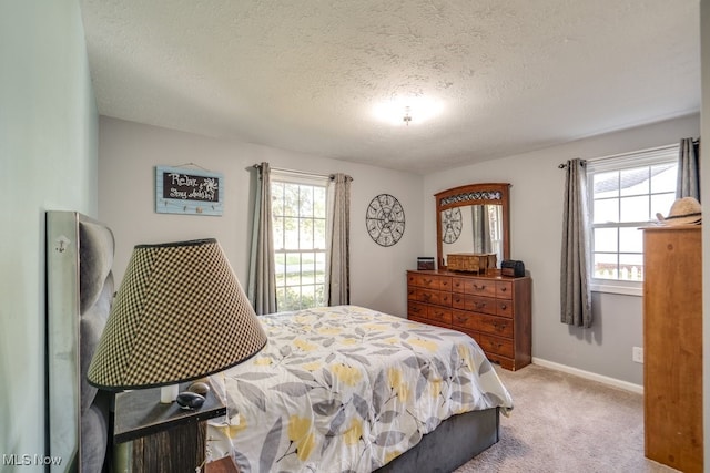 carpeted bedroom featuring a textured ceiling and multiple windows