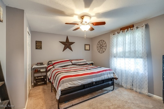 bedroom with light carpet, a textured ceiling, and ceiling fan