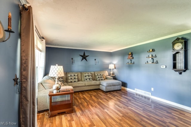 living room featuring ornamental molding, hardwood / wood-style flooring, and a textured ceiling