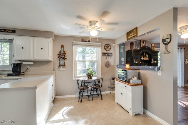 kitchen with ceiling fan, white cabinetry, light wood-type flooring, and a healthy amount of sunlight