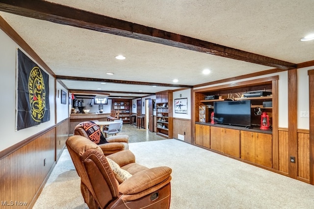 living room with beam ceiling, carpet, and a textured ceiling