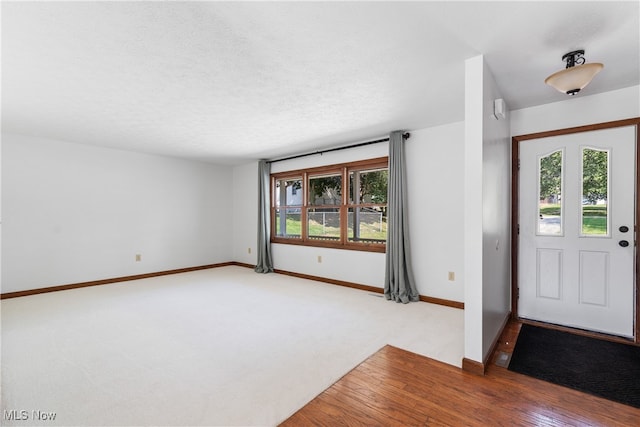 carpeted foyer entrance featuring a textured ceiling