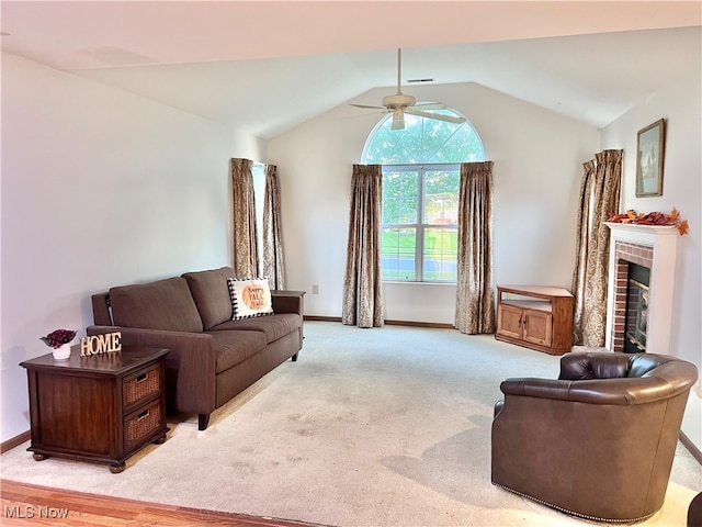 carpeted living room featuring a brick fireplace, ceiling fan, and vaulted ceiling