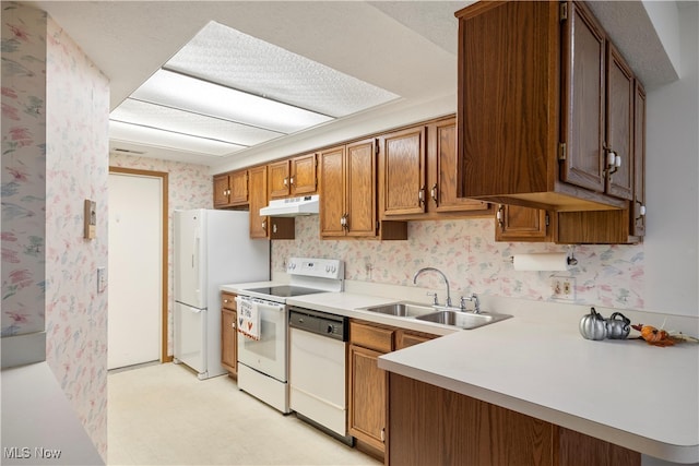 kitchen featuring kitchen peninsula, sink, and white appliances