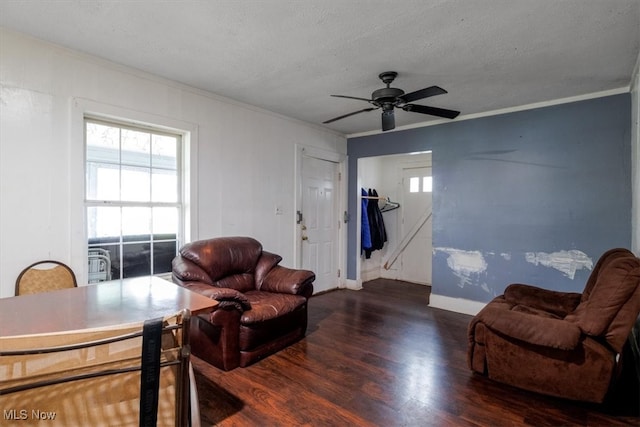 living room featuring a textured ceiling, ceiling fan, ornamental molding, and dark hardwood / wood-style flooring