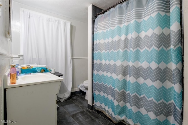 bathroom with walk in shower, vanity, toilet, and tile patterned floors