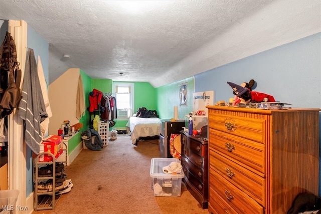 bedroom with lofted ceiling, carpet, and a textured ceiling