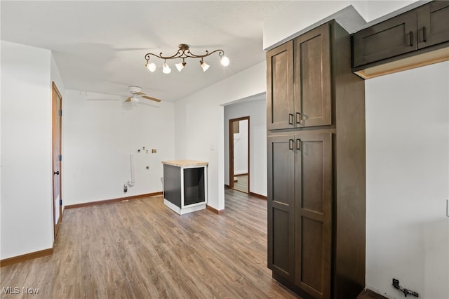 kitchen with dark brown cabinets, light wood-type flooring, and ceiling fan