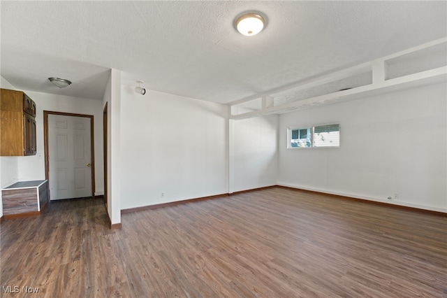 unfurnished room featuring a textured ceiling and dark hardwood / wood-style flooring