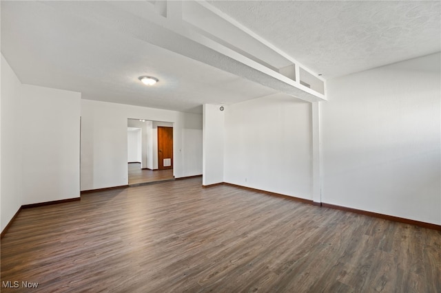 unfurnished room with a textured ceiling and dark hardwood / wood-style flooring