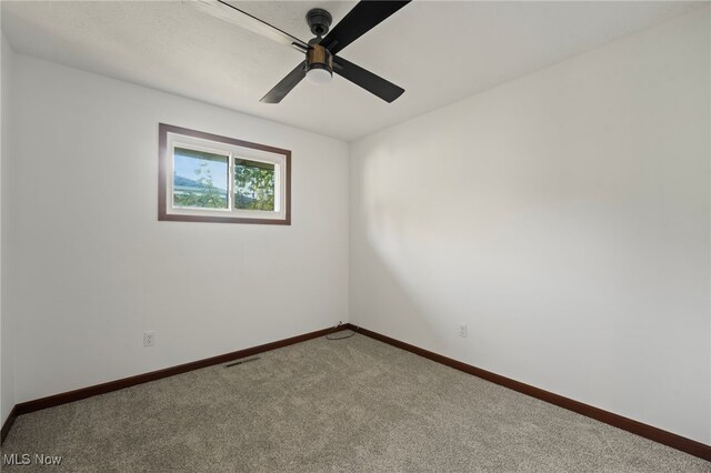 carpeted empty room featuring ceiling fan