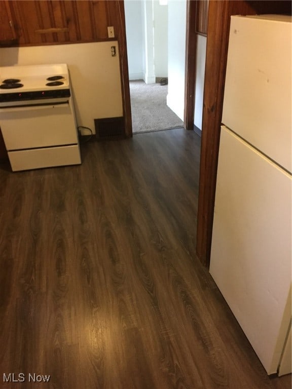 kitchen featuring white appliances and dark hardwood / wood-style flooring