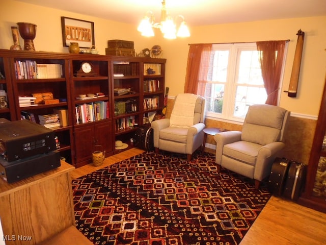 sitting room with hardwood / wood-style flooring and a chandelier