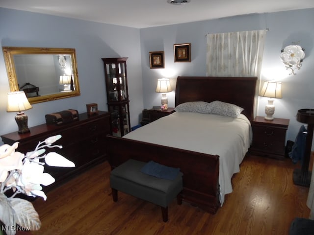 bedroom with dark hardwood / wood-style flooring