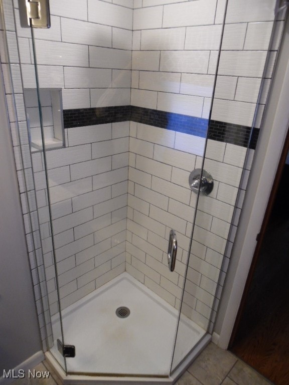 bathroom featuring walk in shower and tile patterned flooring