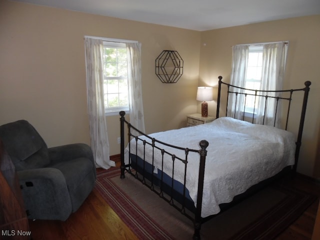 bedroom with dark hardwood / wood-style floors