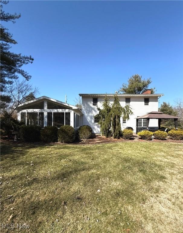120 Woodcrest Dr, Marietta, OH 45750 - view of side of property with a sunroom, a yard, and a chimney