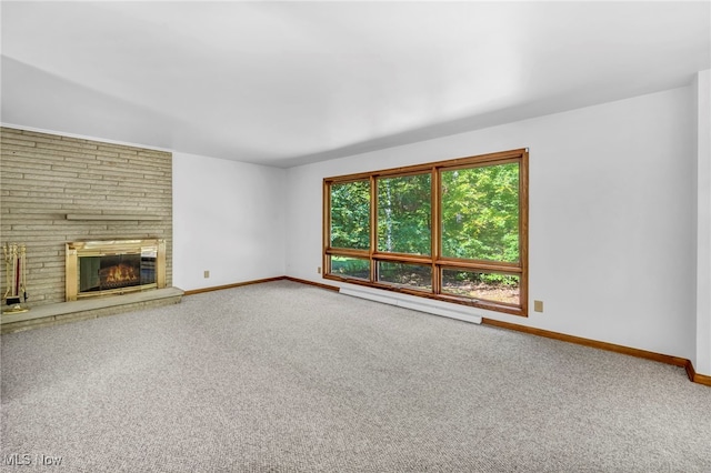 unfurnished living room with carpet flooring, a large fireplace, and baseboard heating