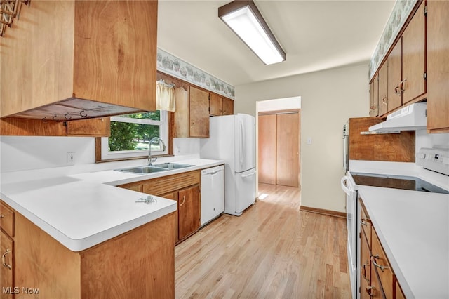 kitchen with kitchen peninsula, light wood-type flooring, white appliances, and sink