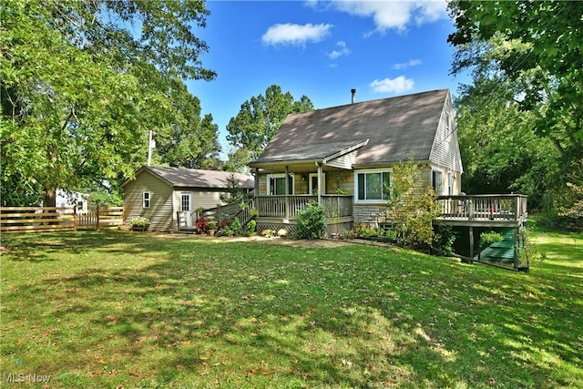 back of house featuring a deck and a lawn