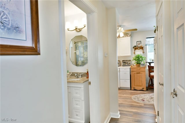 corridor featuring sink and light hardwood / wood-style flooring