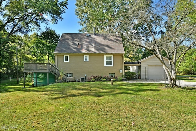 back of property with a yard, a wooden deck, and a garage